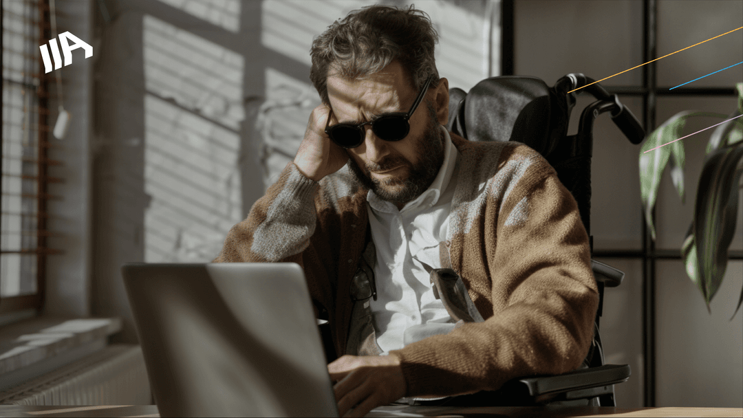 A blind person wearing sunglasses and a cardigan is sitting in a wheelchair, looking at a laptop with a thoughtful expression.