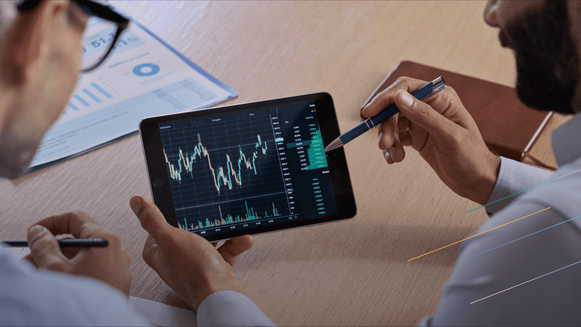 two individuals are looking at the chart on a tablet