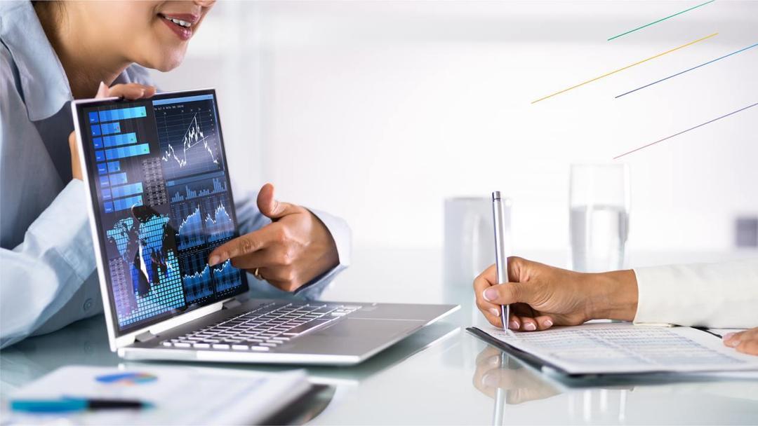 Two people are examining the statistics charts on a laptop