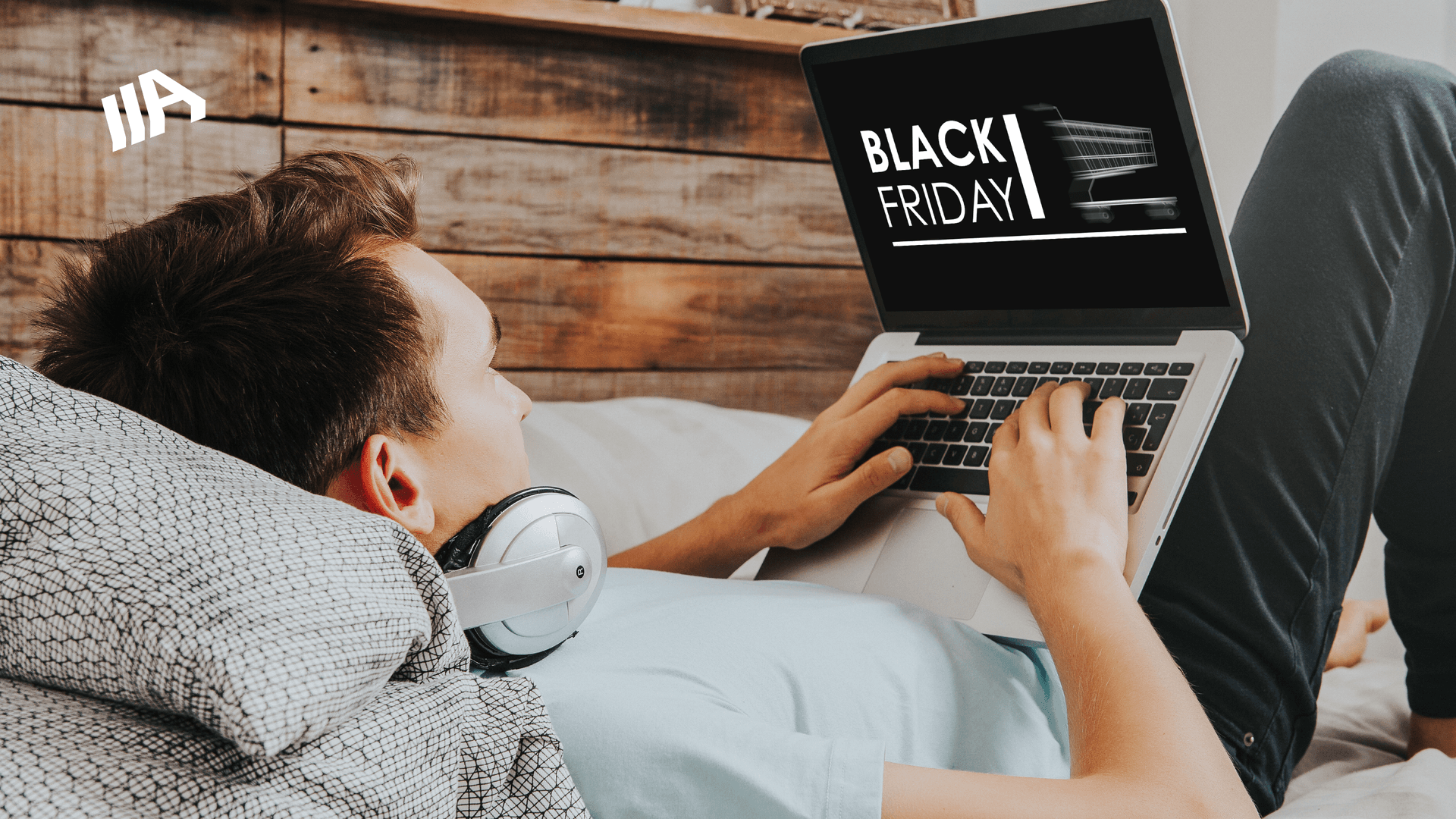 A man lying on the couch, looking at a laptop with Black Friday written on it.